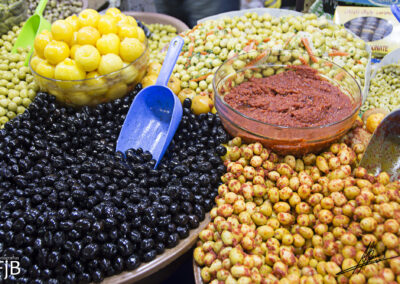 Distintos tipos de aceitunas y aperitivos en un bazar de Nador